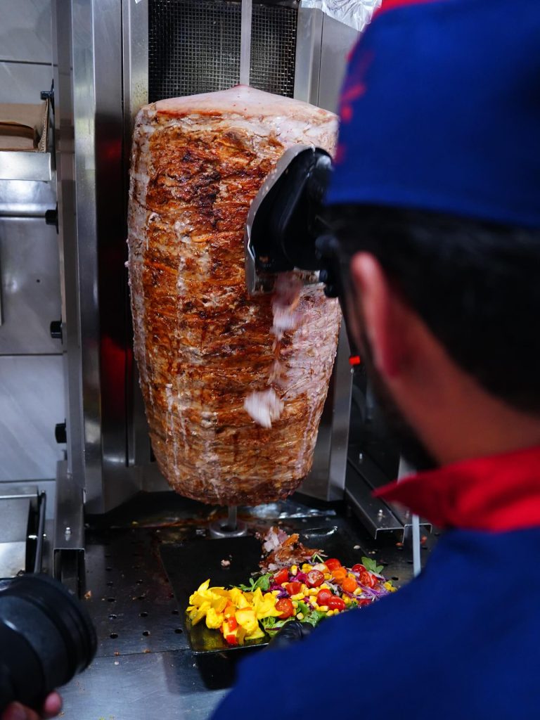 Découpe de la broche veau mariné en cuisine chez Wan Kebab Clermont-Ferrand